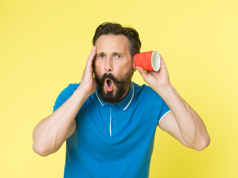 Ear and hearing care. Mature man suffer deafness or hearing loss. Hearing disorder. Hearing testing. Bearded man listen through glass. Special agent or spy. Spying and eavesdropping Appareil auditif ou entrainement auditif, protection anti bruit