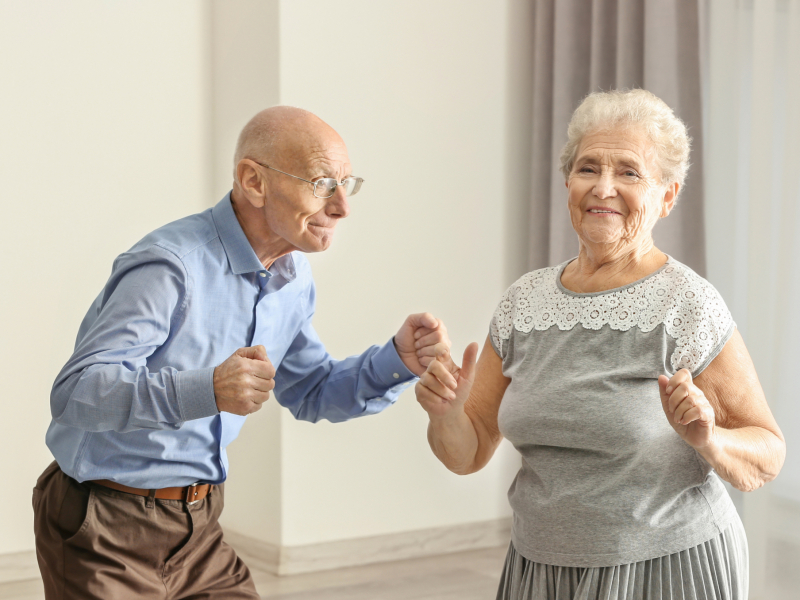 Cute elderly couple dancing at home acouphènes, remboursement appareils auditifs